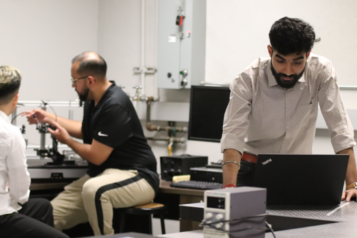 Dr Travis Hu and students working separately in BNMI lab