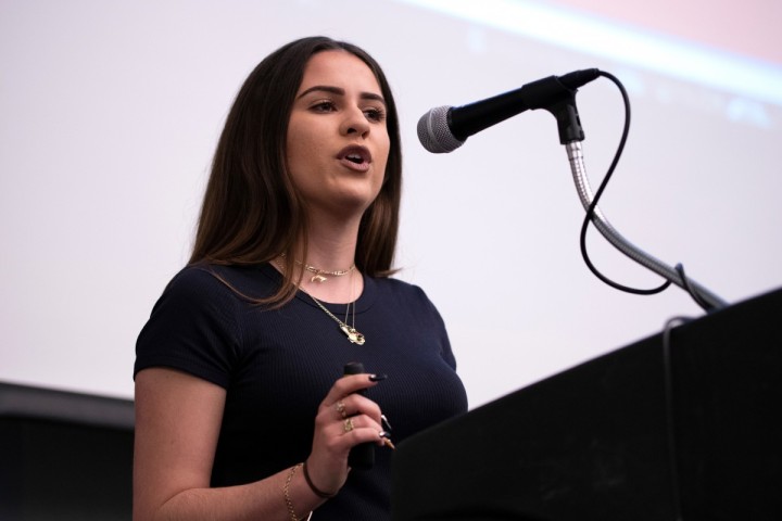 Woman in from of microphone speaking