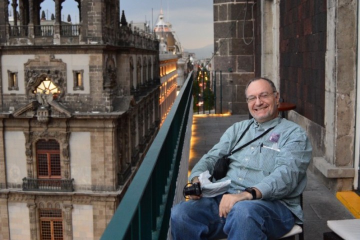 Aguilar smiling and sitting on a balcony