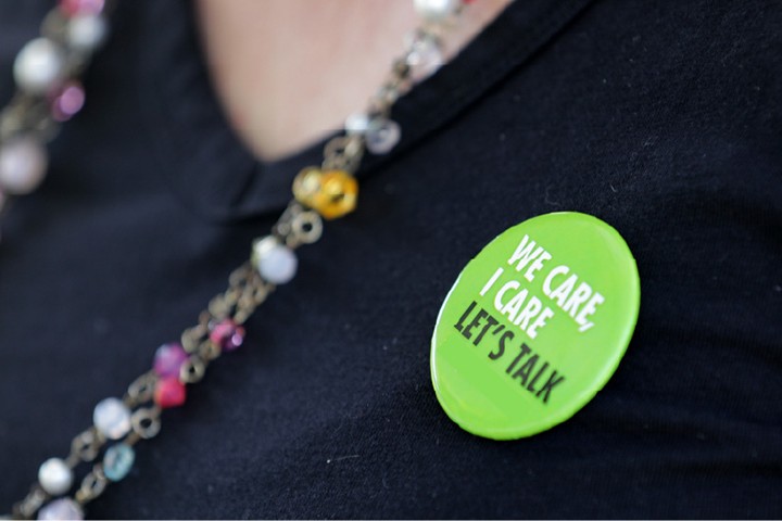 Close-up of a button that says "I care, we care, let's talk."