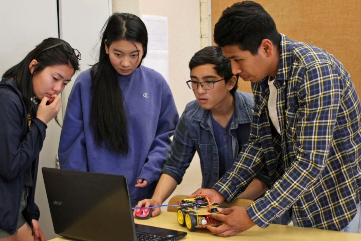 students looking at laptop screen testing project connections