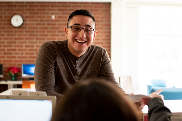 Student worker helps a student at a department front desk