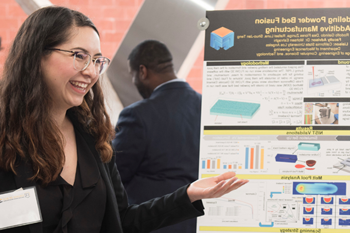 student stands beside her project poster