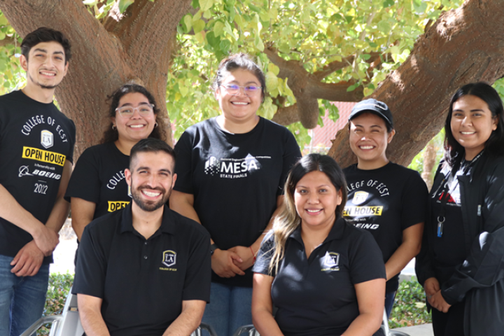 ecst students and staff stand by tree smiling