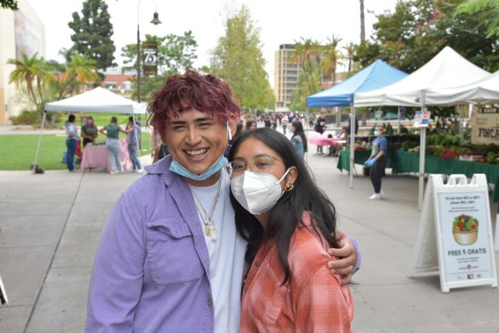 students embracing at the main walkway on campus during the market