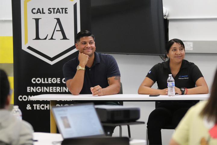 industry speakers sit behind table facing students in classroom