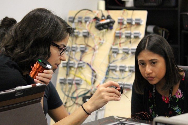 female ECST student facilitator hold wire and explains to student