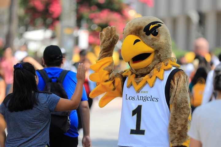 eddie the eagle high 5's student on walkway