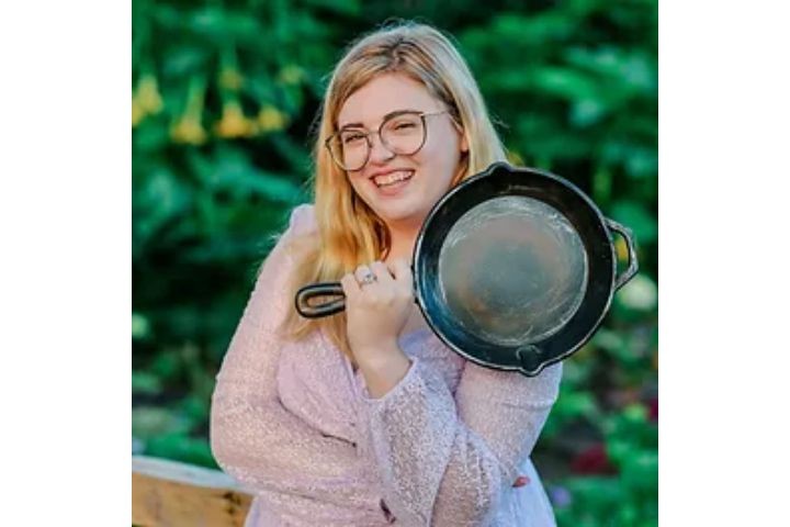 Fight choreographer Roxanne Westerlin, smiling, holding a cast iron pan