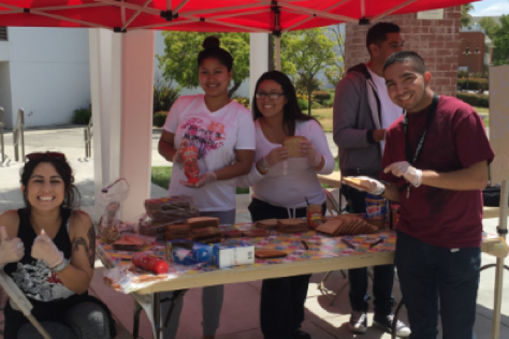 Students posing outside at a booth.