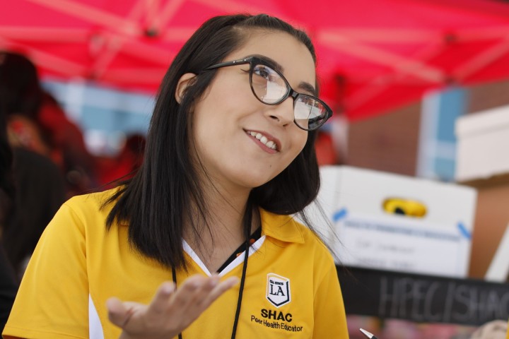 A student smiling while looking up at someone.