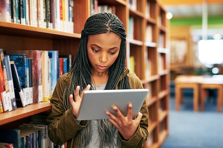 Student uses iPad in library