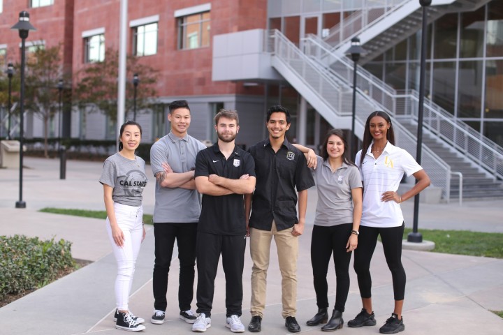 Group of students wearing Cal State LA branded clothing standing outsize of La Kretz Hall