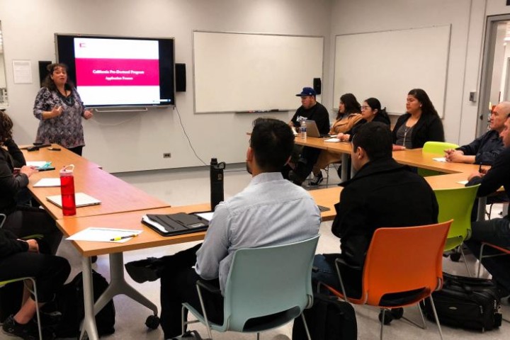 Dr. Brown speaks to a room of students in front of a smartboard