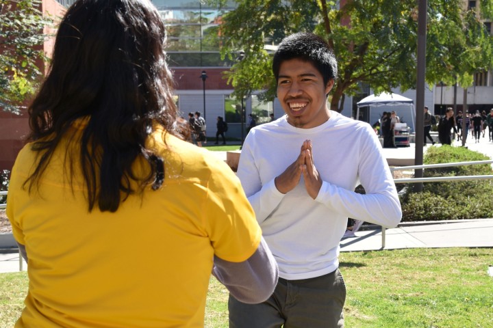 Student smiling while holding a yoga pose.