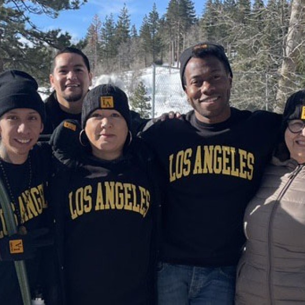 Five people standing outside in the snow.