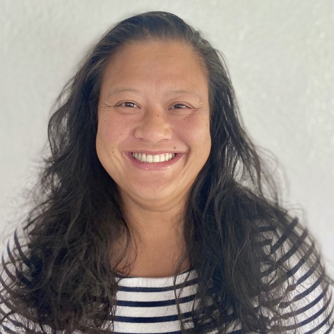 A person with long hair smiling.