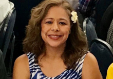 a person in a blue and white dress smiles at the camera