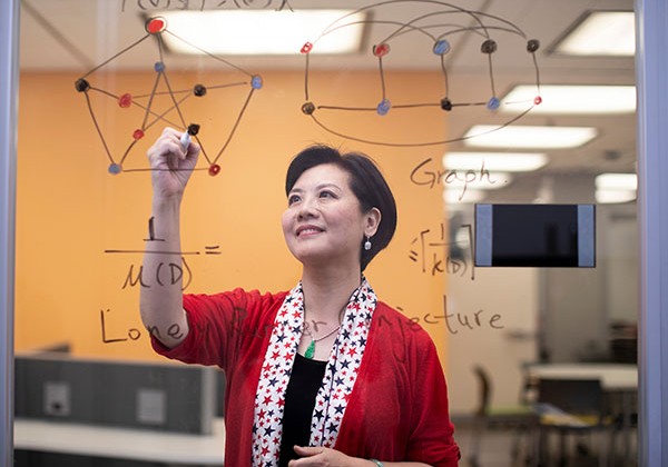 Faculty member writing math equations inside the library