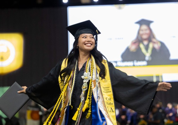 A graduate celebrating during a graduation ceremony.