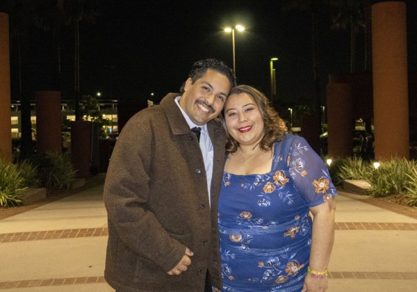 Couple smiling together outdoors at night beneath campus columns at Cal State LA.