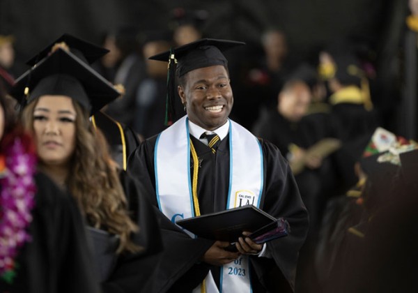 A graduate walks at commencement ceremony.