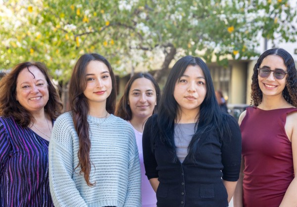 A group of students standing together on a sunny day.
