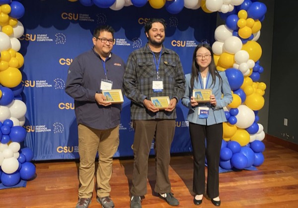Three students pose for photo with their awards.