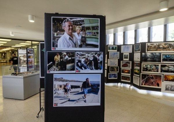Photo exhibit of Eagle2025 on display at Cal State LA, showing large printed photos and concept art panels mounted on black boards throughout the gallery space.