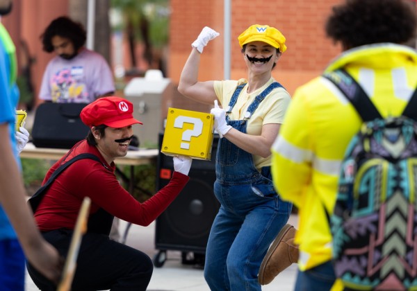 EagleCon attendees dressed as Mario and Wario pose with a yellow question-mark block.