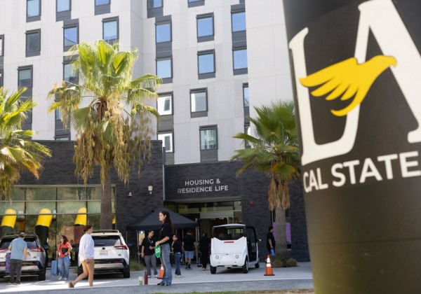 Students and staff gather outside Cal State LA Housing and Residence Life during move-in day.