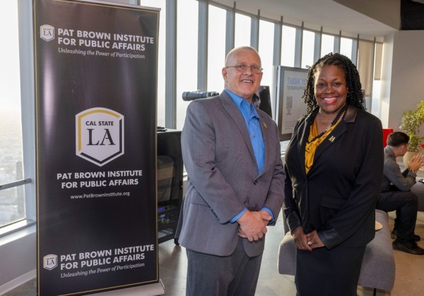 President Berenecea Johnson Eanes the PBI Director pose beside a Pat Brown Institute for Public Affairs banner during a Cal State LA event.