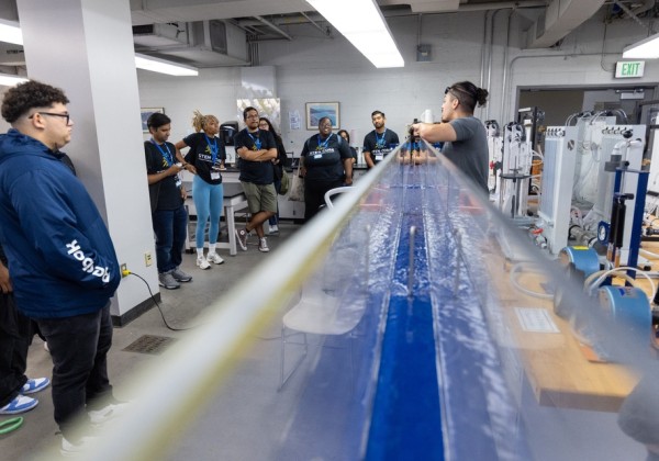 Students gather in a Cal State LA lab for a STEM CORE demonstration involving fluid dynamics equipment.