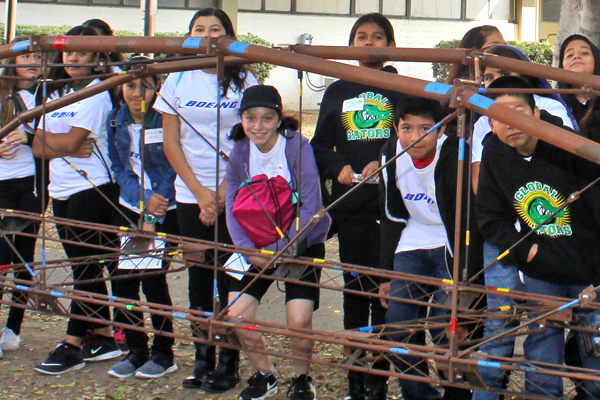 students stand behind steel bridge