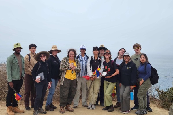 Group of students posing in front of coastline