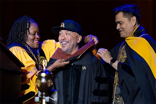 Jo Koy being hooded by President Eanes and Trustee Vargas