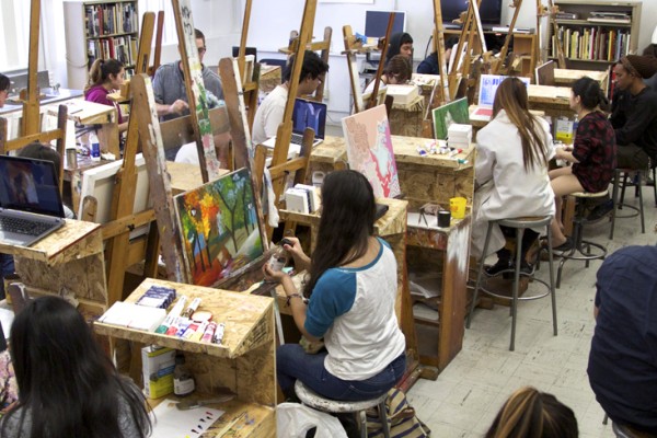Image of students in a painting studio with easels, shot from above