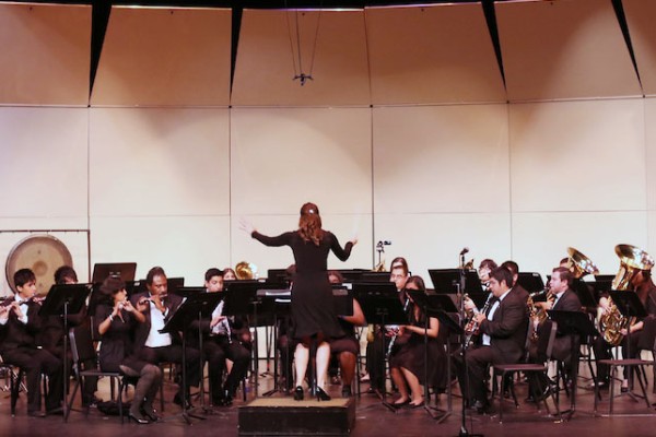 Image of a conductor in front of an orchestra of student musicians on stage