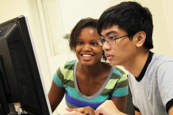 Two Honors College students facing a computer screen intently. 