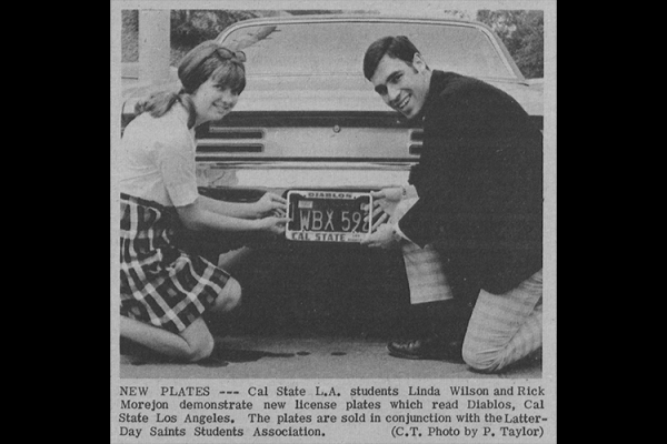 Two students posing with Cal State LA Diablos license plate frame