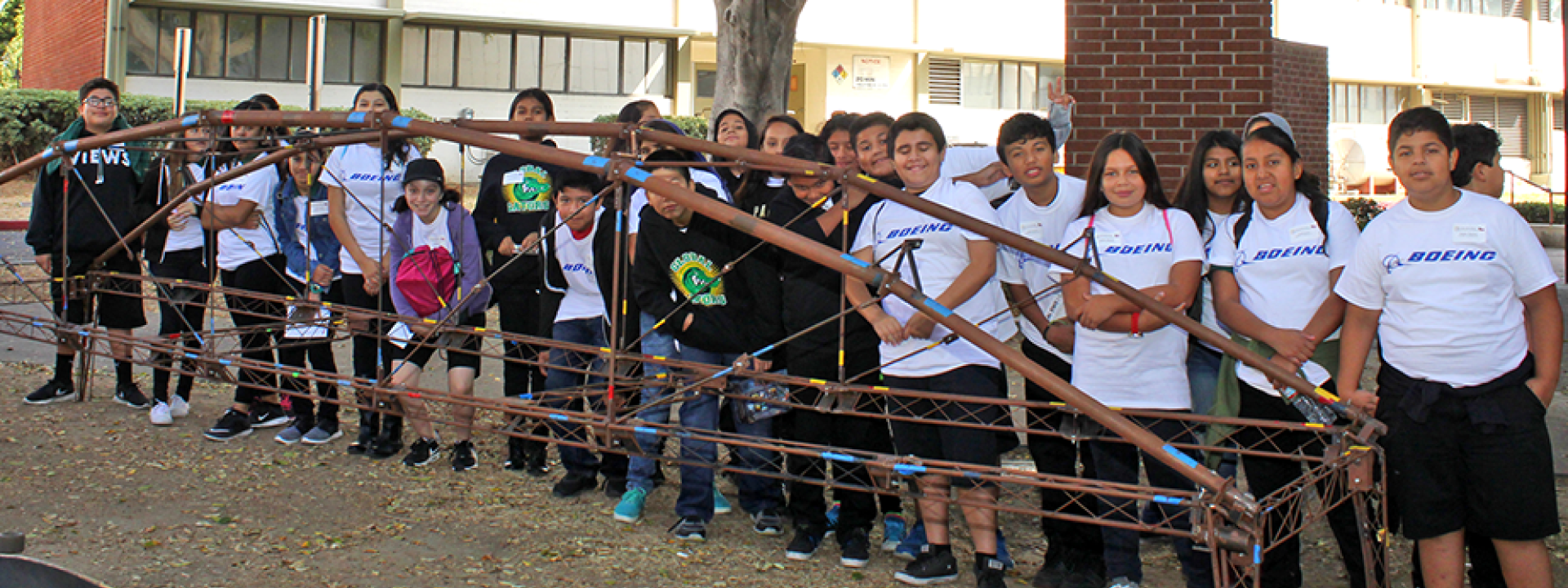 students stand behind steel bridge