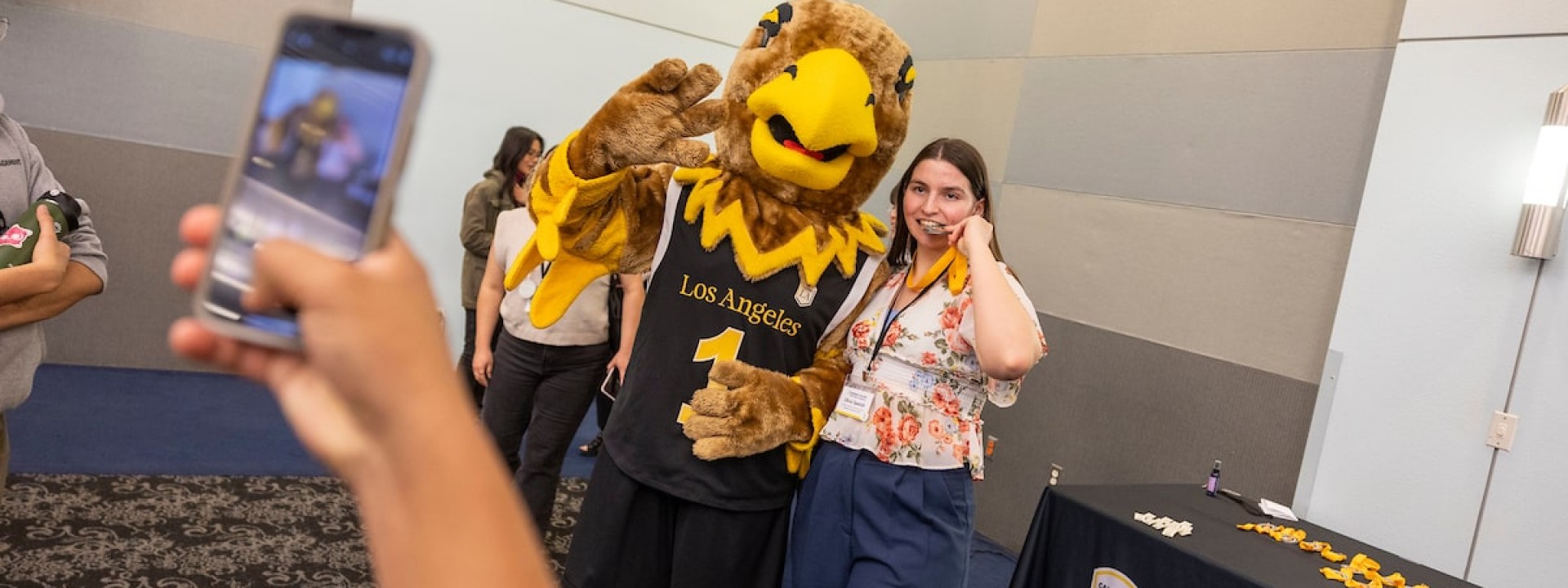 Eddie the Eagle giving a thumbs up with a student