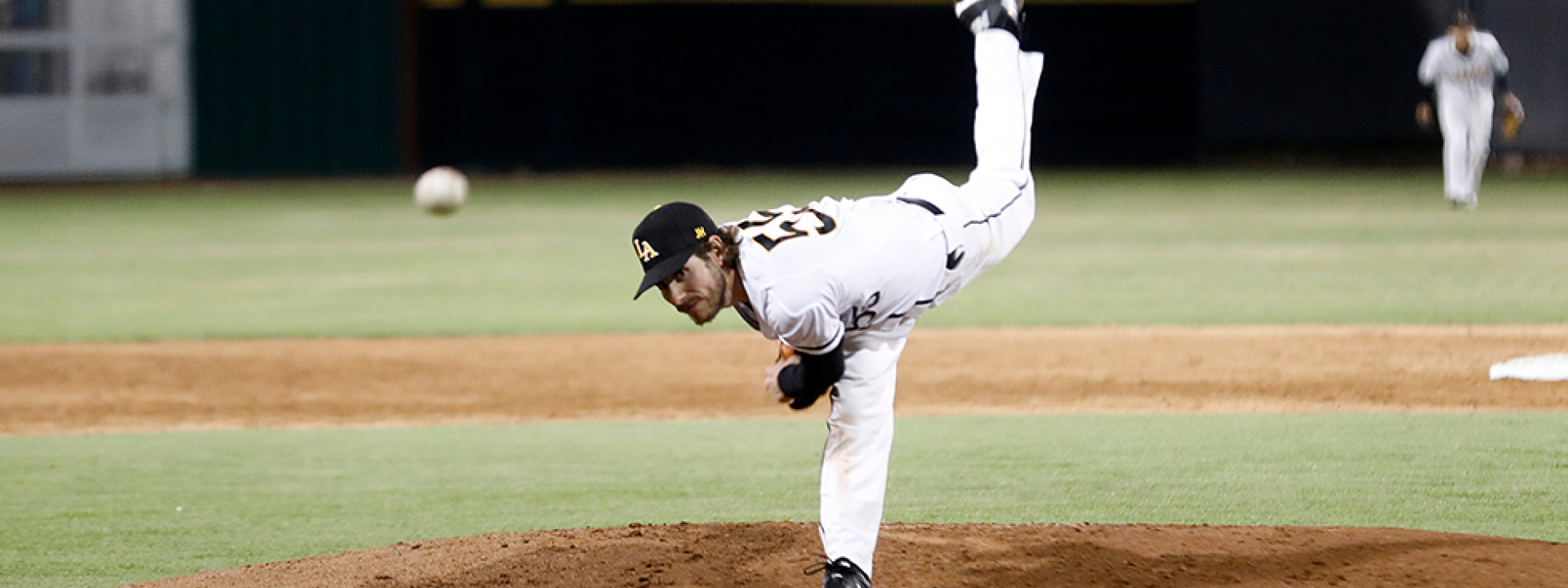 Image of a Cal State LA pitcher on the mound, mid-throw. 