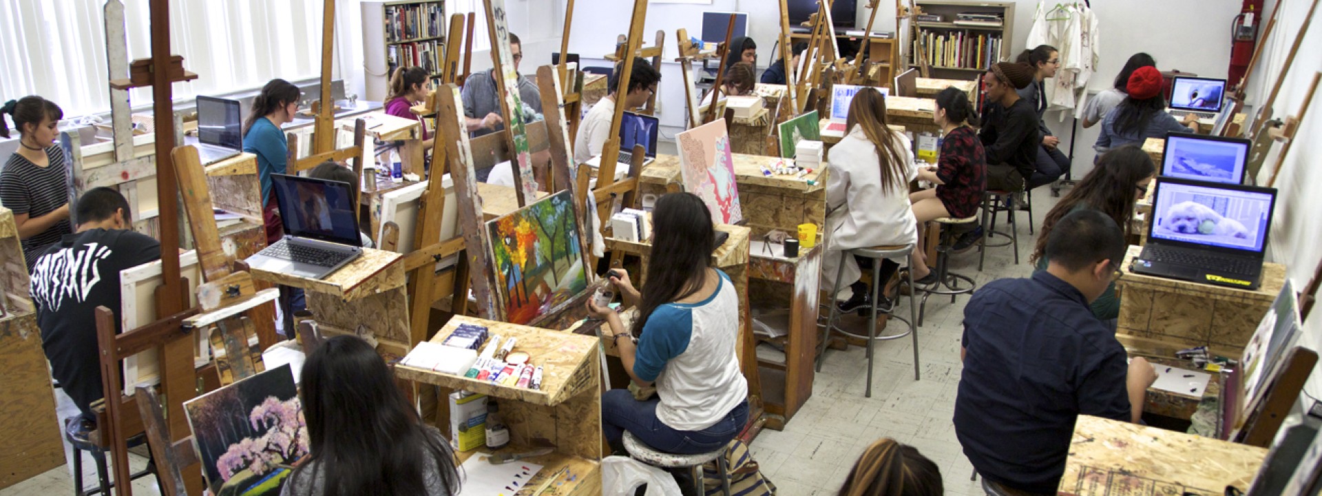 Image of students in a painting studio with easels, shot from above
