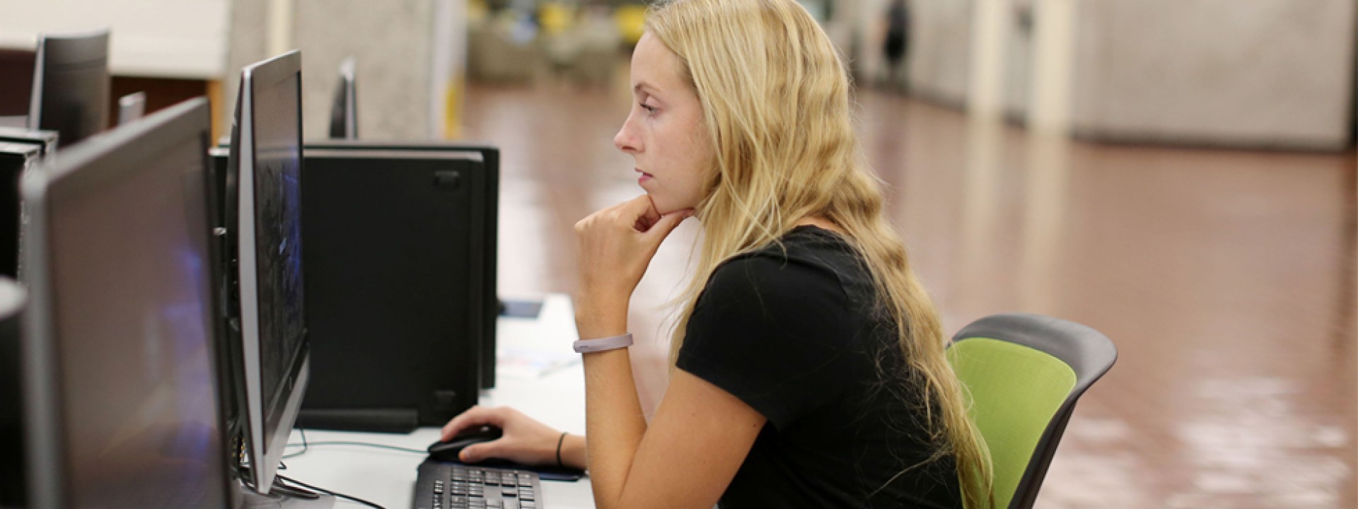 Image of female student in University Library using a computer station. 