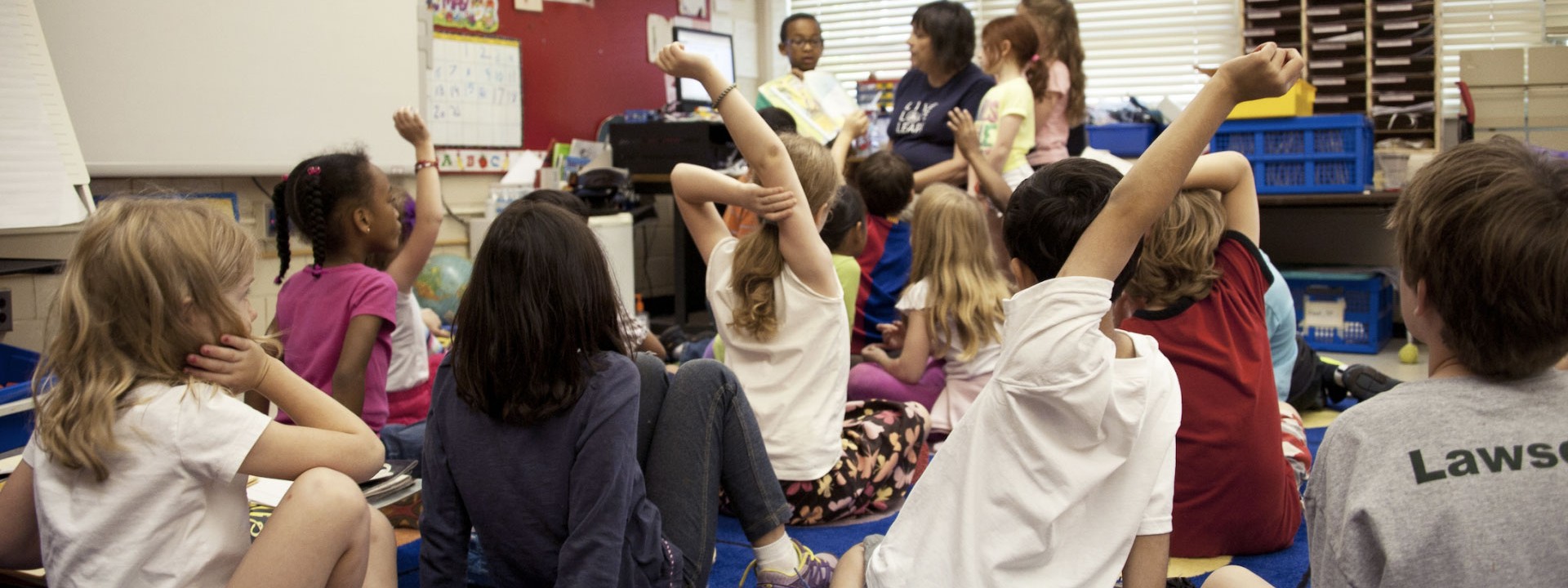 student raising hand in the classroom