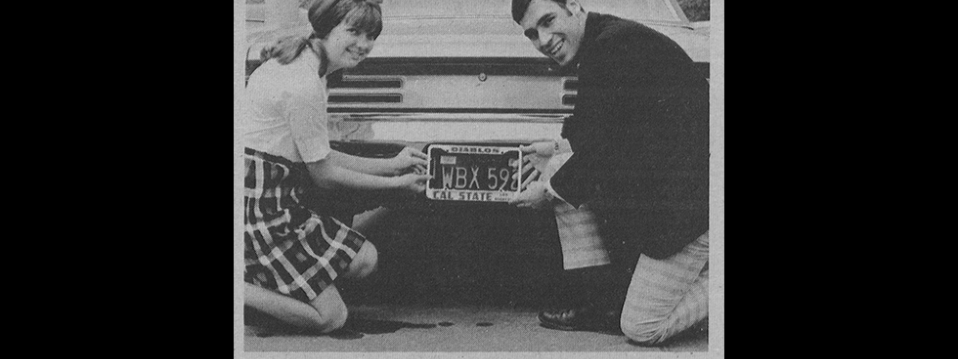 Two students posing with Cal State LA Diablos license plate frame
