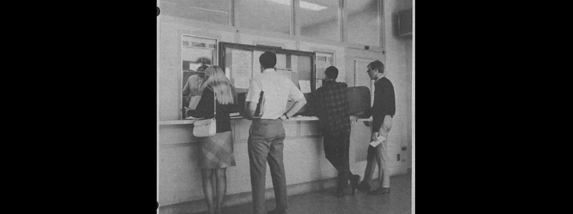 Four students standing at cashier window for spring enrollment