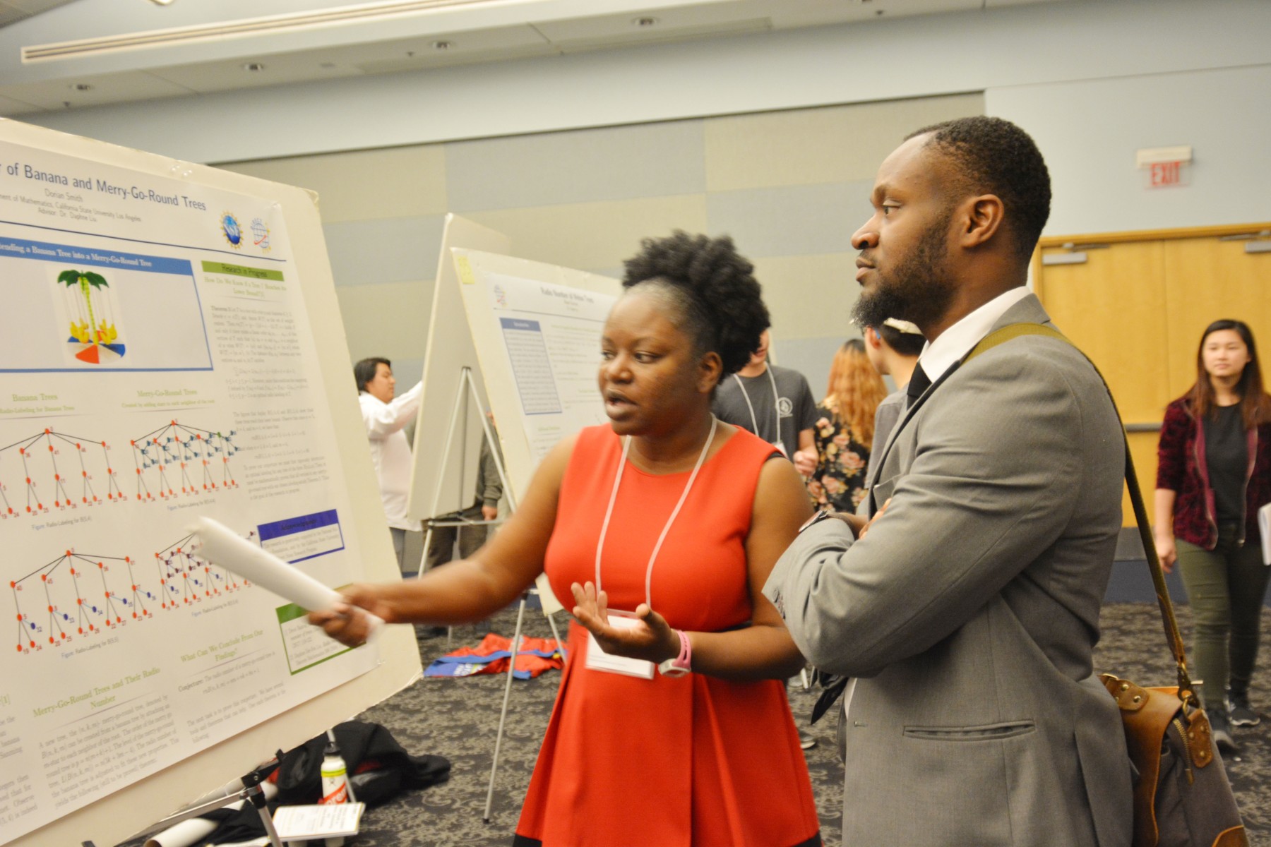 student discussing her poster presentation with attendee