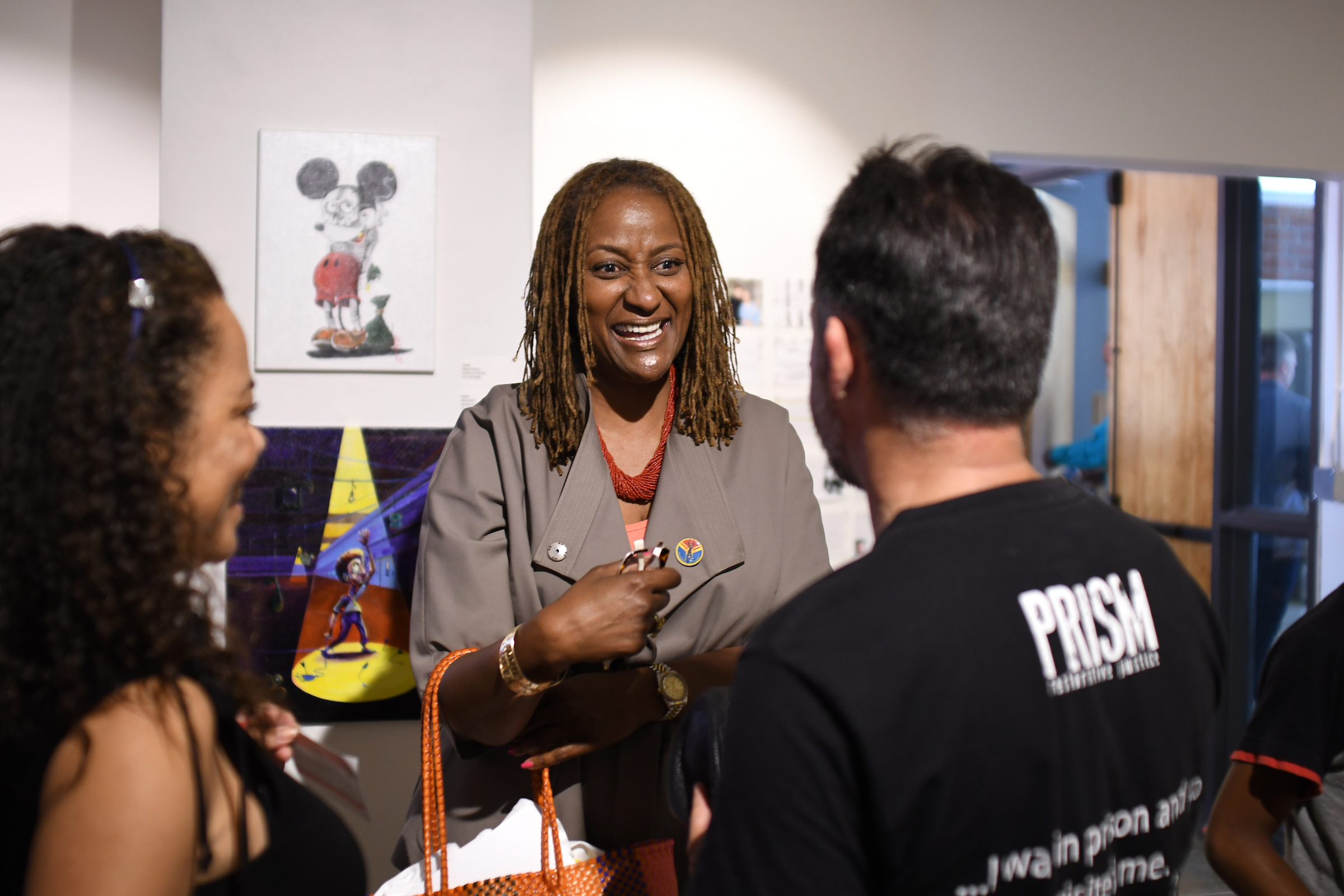 State Sen. Holly Mitchell (center) talks to two people